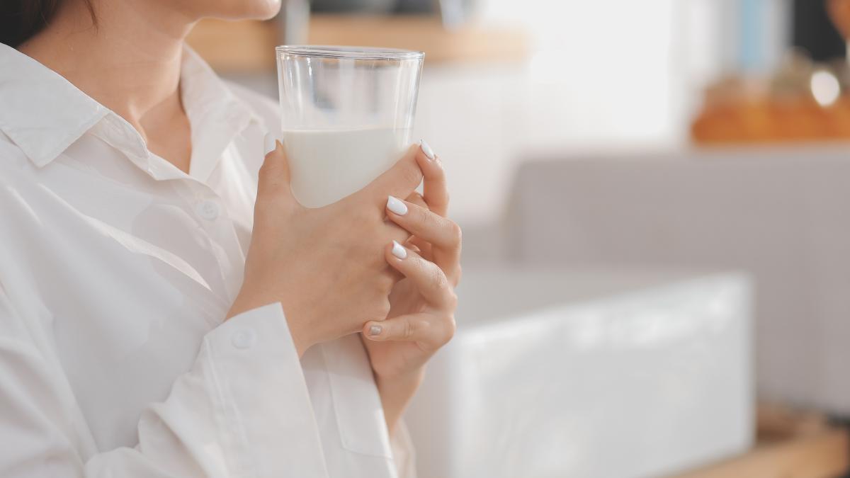 portrait-satisfied-young-asian-woman-drinking-milk-from-glass-isolated-white-background_88627000