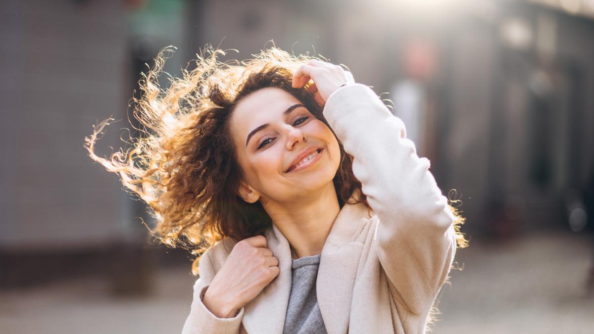pretty-woman-with-curly-hair-walking-autumn-coat_18003700