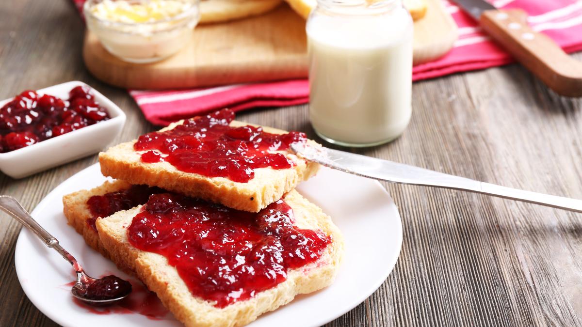 bread-with-butter-homemade-jam-plate-wooden-table-closeup_02878000